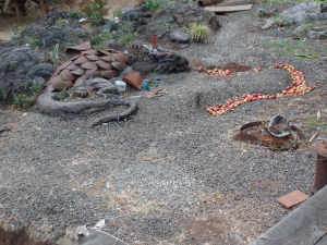 Darcy the dragon, made of cement and shovelheads, breathing apple fire.